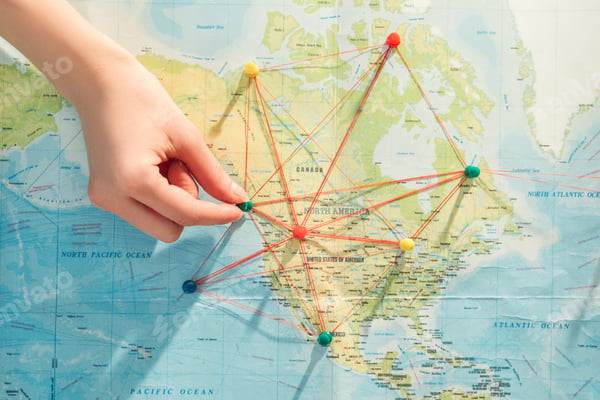 Pins and string mapping connections on a world map